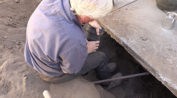 Man installing a pipe under ground
